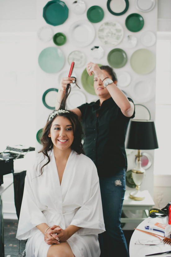 The bride getting all dolled up. Our plate wall is the perfect backdrop!
