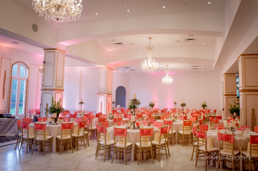 A little bit of color goes a long way. Coral rosette chair ties and blush uplighting warmed the reception up.